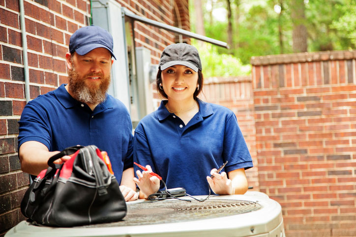 Ac Specials Two technicians diagnosing A/C unit