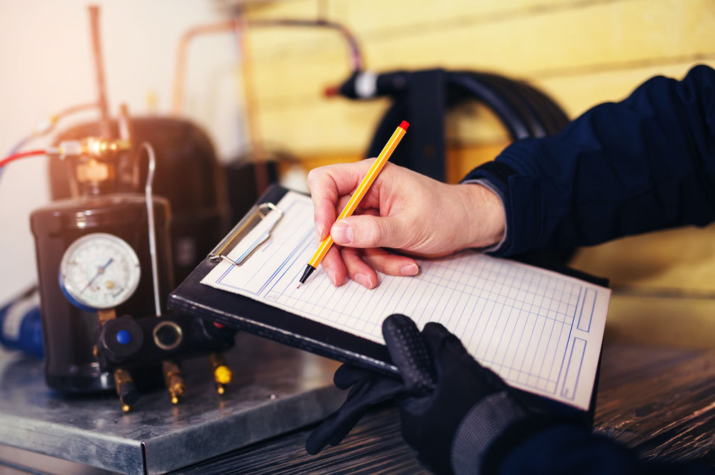Heating Repair Technician writing diagnostic notes on pad