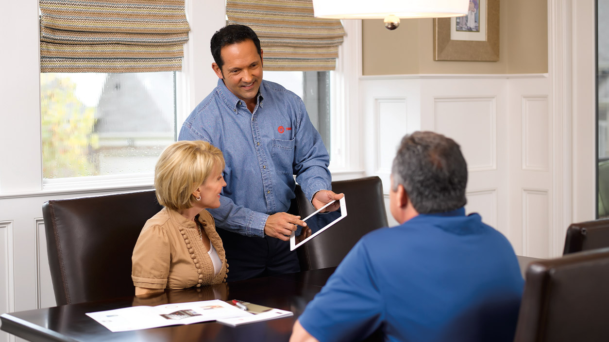Technician discussing services in home with customers