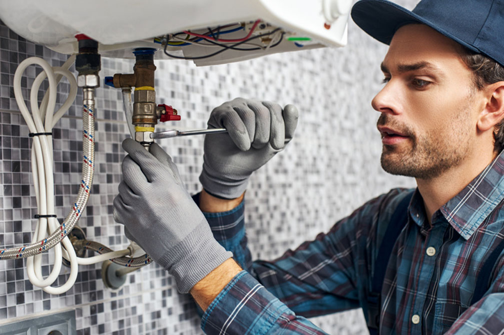 Technician repairing sink in kitchen