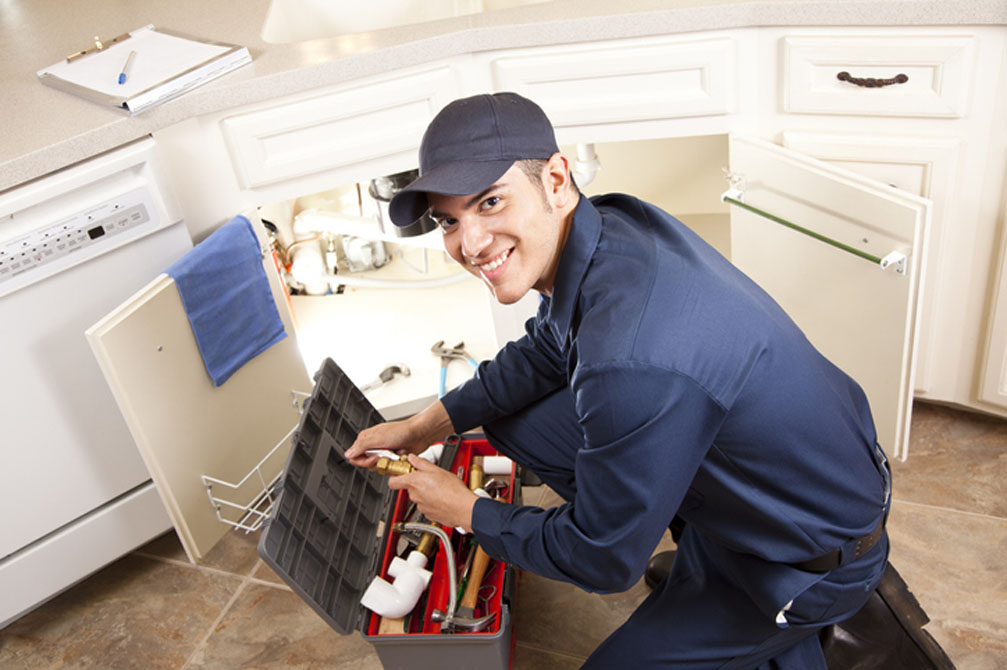 Technician repairing sink in home